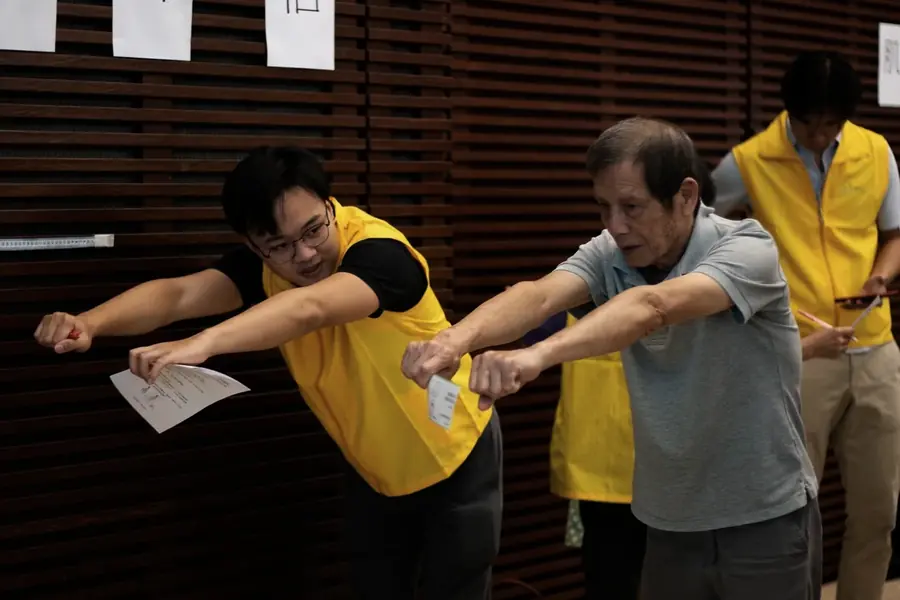 A chiropractor measuring a participant shoulder range of motion at an HKCCF community health day